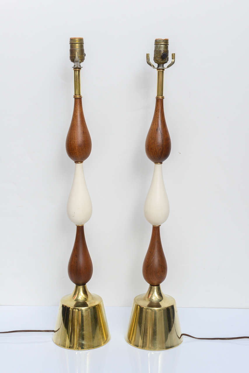 Pair of tall three teardrop form, teak and brass table lamps made by Laurel Manufacturer in the 1960s. The middle 