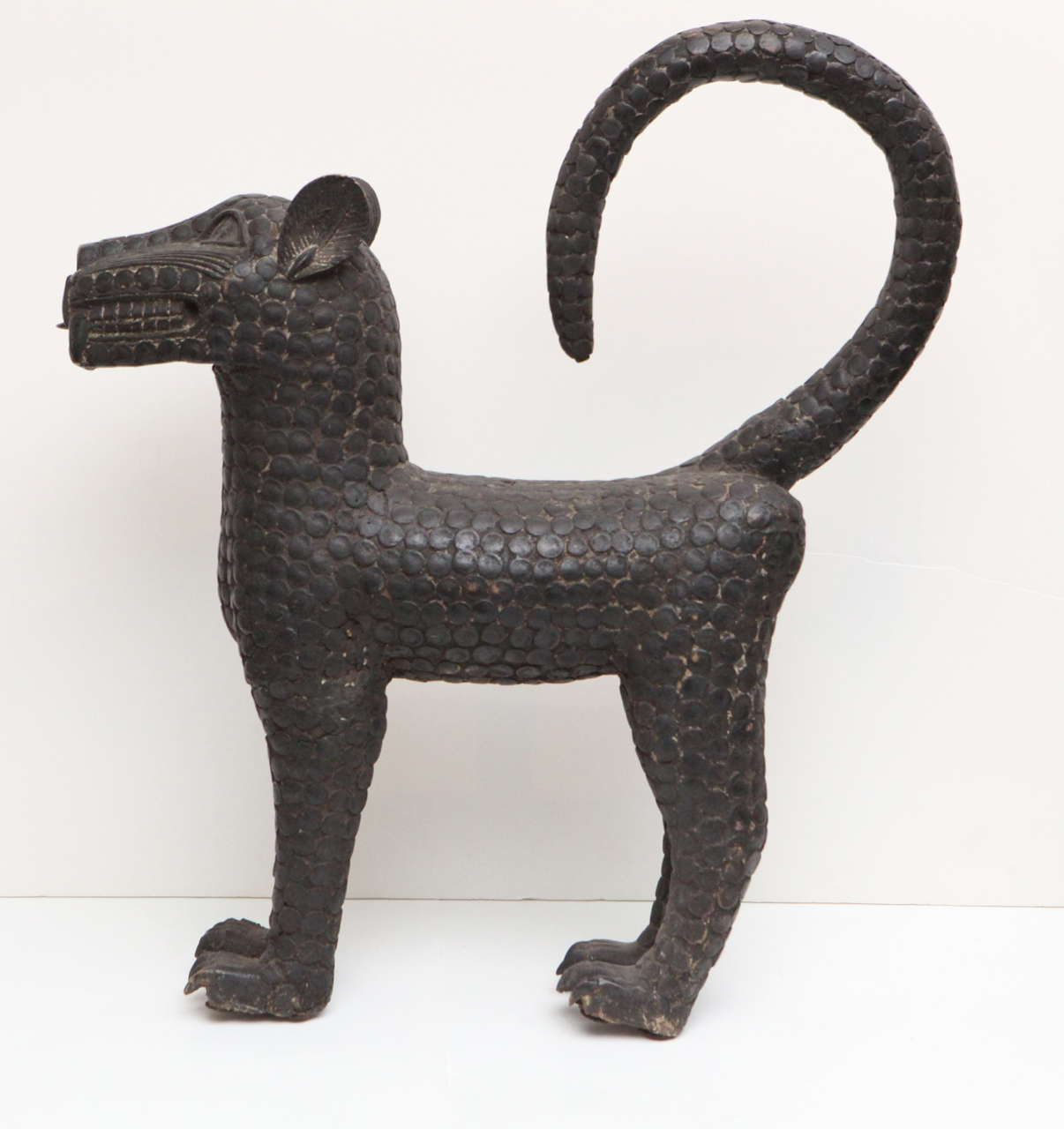 Stylized bronze leopard sculpture with raised circles representing fur.
