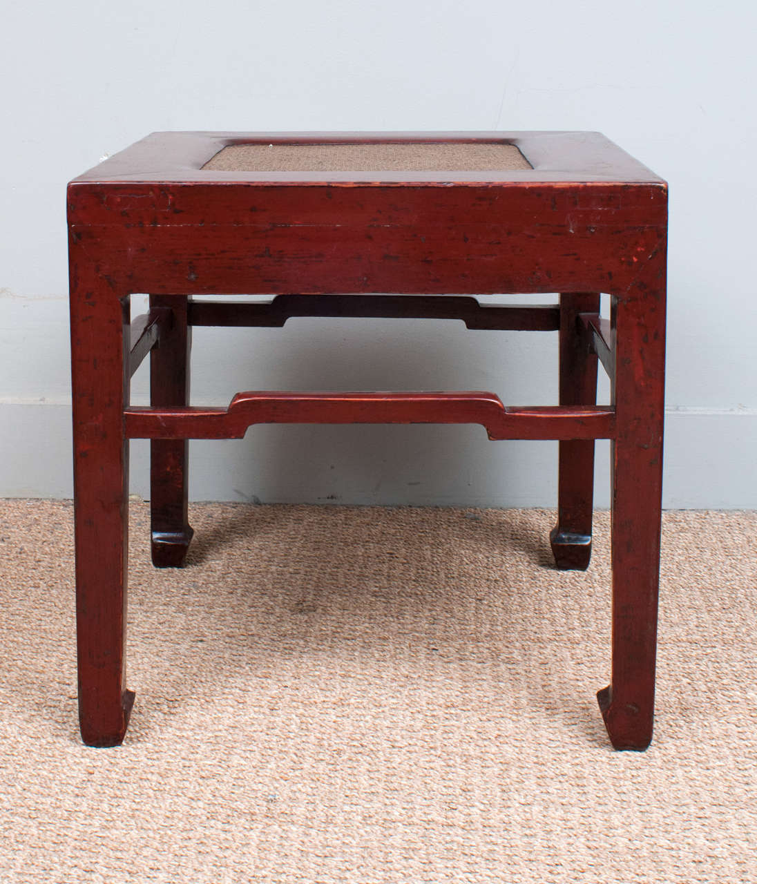 Pair of Chinese red lacquer low tables with hard cane insert and flat sides. The original lacquer and patina has been expertly conserved.