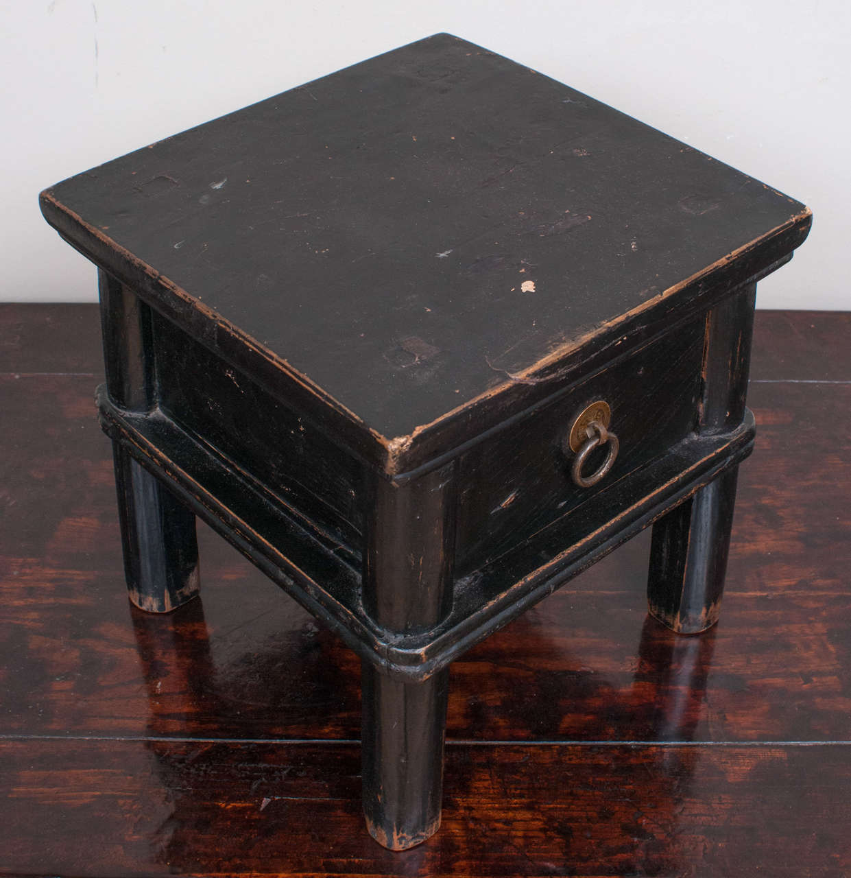 Black lacquer square footstool with drawer.