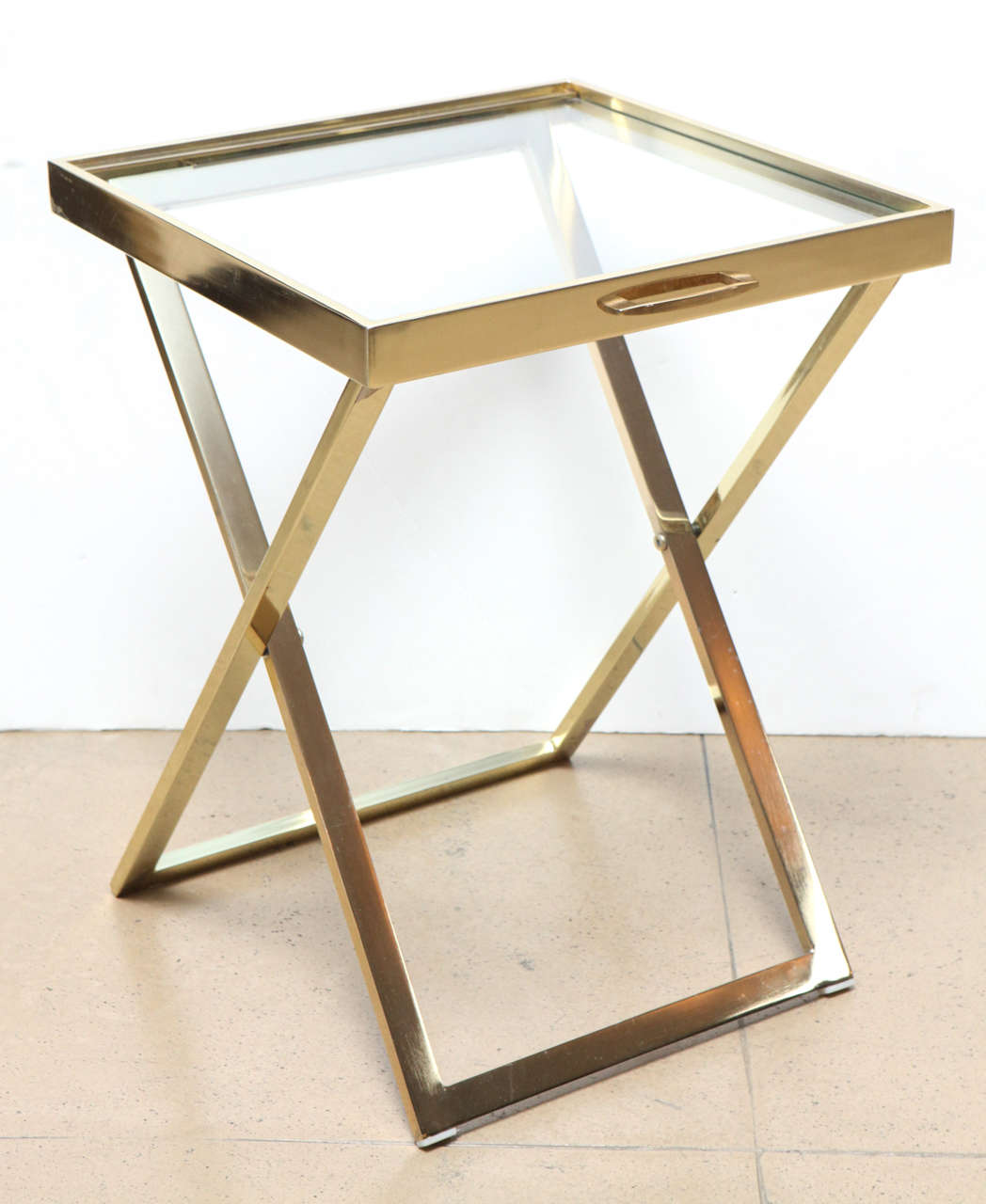 1970s Italian glass and brass tray atop a folding brass stand.