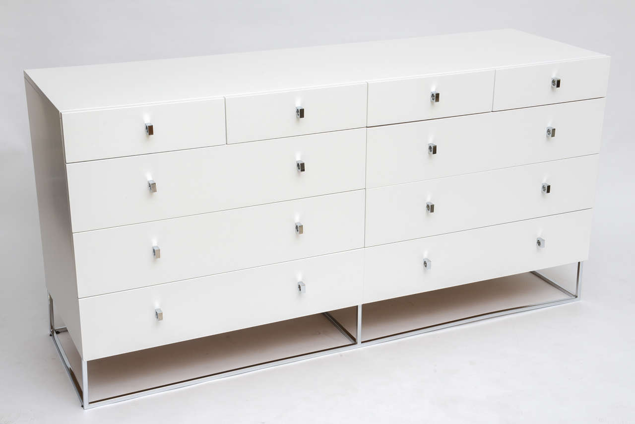 Sleek and modern, satiny white dresser by Rougier floats on a polished chrome square tube frame, in the manner of Milo Baughman. Two short matching wardrobes are also available. Restored.