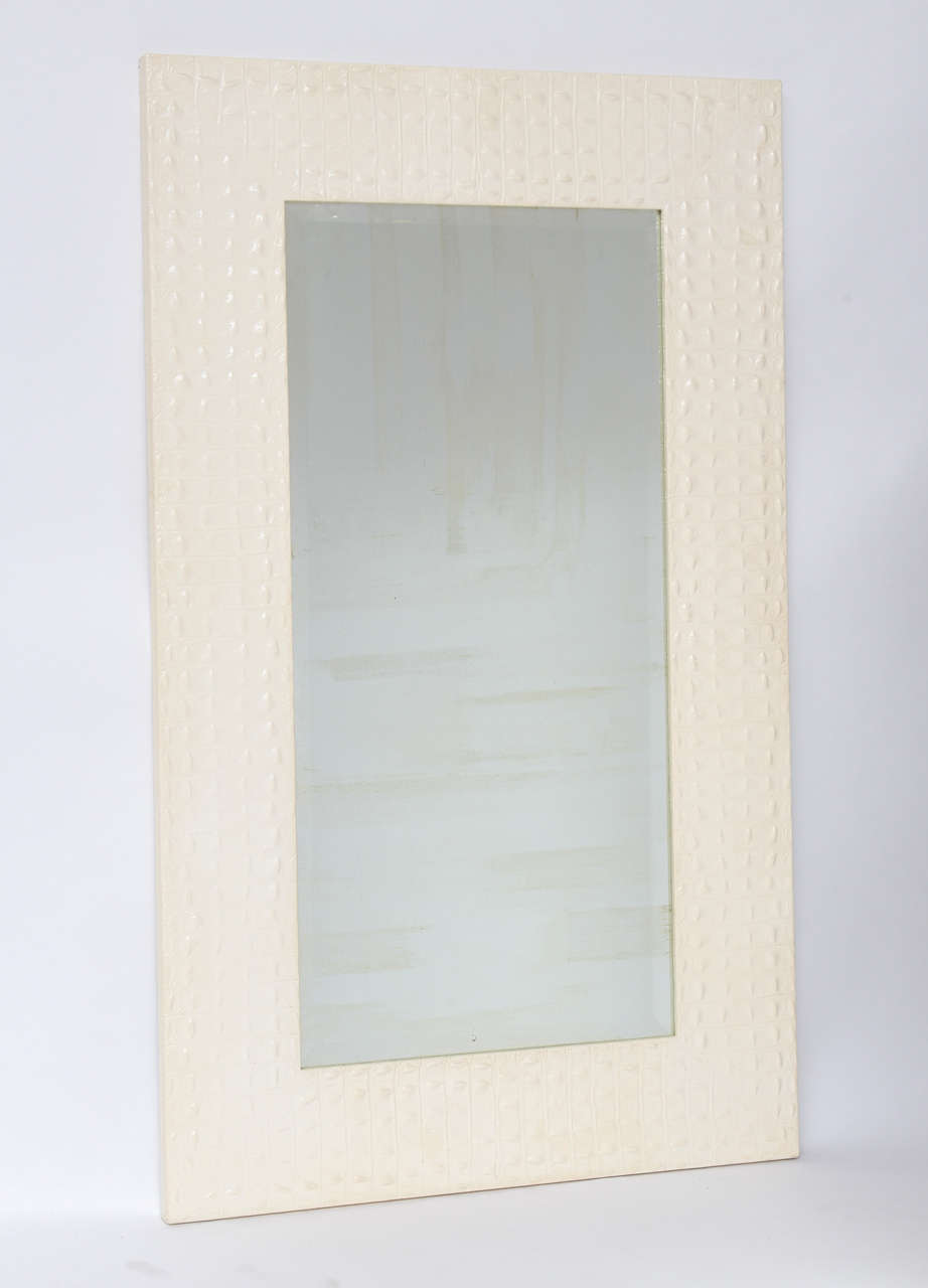White painted crocodile-embossed leather mirror by Karl Springer, circa 1980. We've left it with its original bevelled mirror, despite internal silvering loss, but will replace at customer's request.
