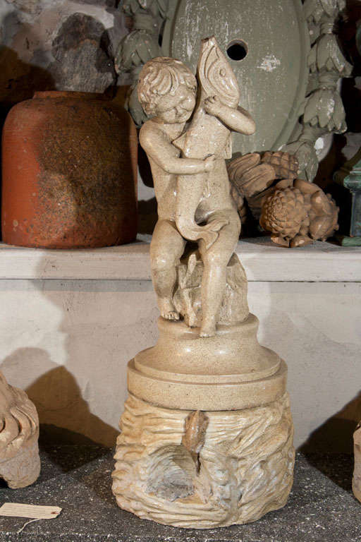 This is a very unusual and lovely fountain in two parts with a frog-decorated rockwood base surmounted with a seated child grasping a fish. It is easy to plumb and place in a small basin for your city garden or on your terrace. Alternatively, it