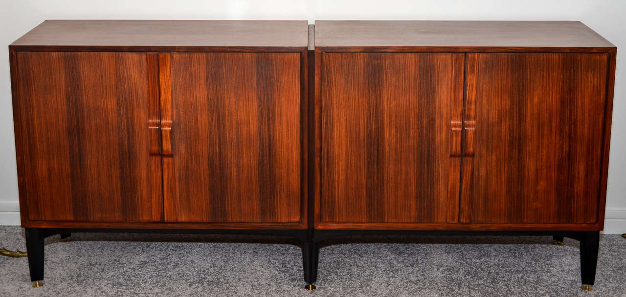 1950's Italian rosewood enfilade buffet with four doors. Sycamore inside. Glass shelves. Blackened wood legs and adjustable brass feet. Good condition. Normal wear consistent with age and use.