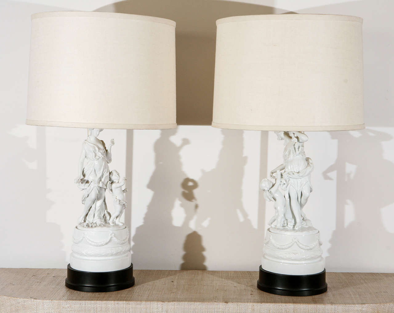 Unique pair of William Haines lamps from the Ann Rutherford Dozier estate in Beverly Hills, 1942.  The lamps have Haines' distinctive pedestal bases and French mounted linen shades, with a pair of original 19th century porcelain figures.  

The