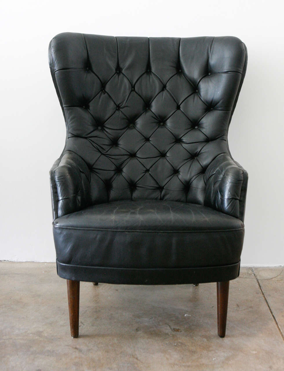 a remarkable tufted leather high back chair from denmark. designer unknown.