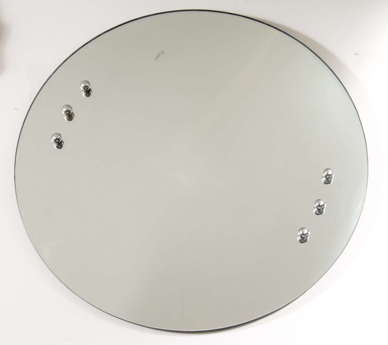 This stunning round mirror is by Donald Deskey the foremost designer of the Art Deco period in America. It is accented with chrome ball detailing.