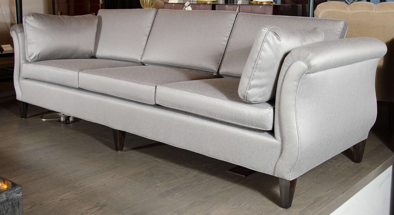This beautiful sofa features a scroll arm design with ebonized walnut feet and has been newly upholstered in a platinum sharkskin fabric.