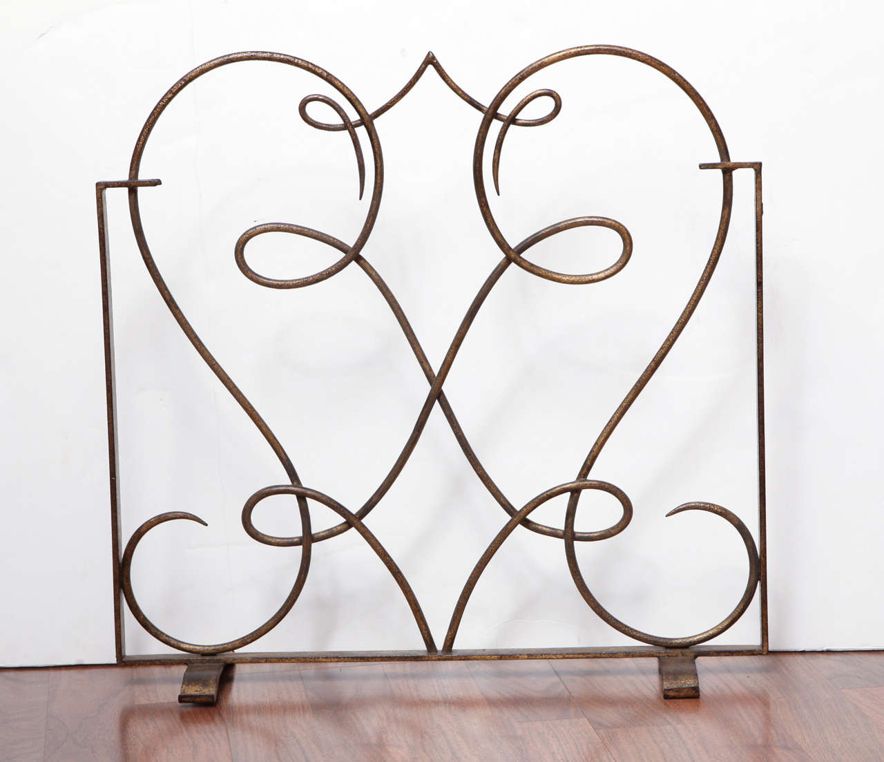 Attributed René Drouet (1899 - 1993)
Gilded iron fire-screen, with openwork of interlaced windings on two skate-feet. 
H: 21 1/2