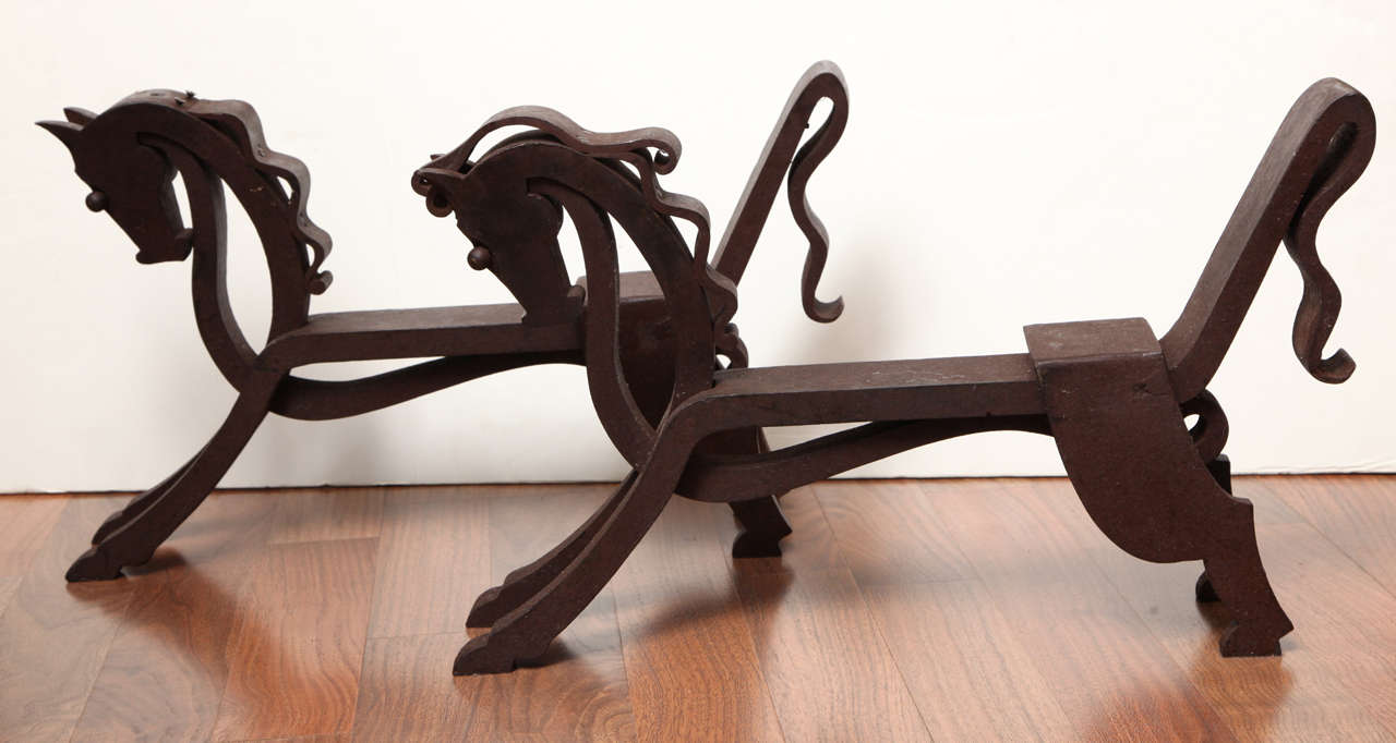 Unusual pair of wrought iron fire dogs with stylized horses.