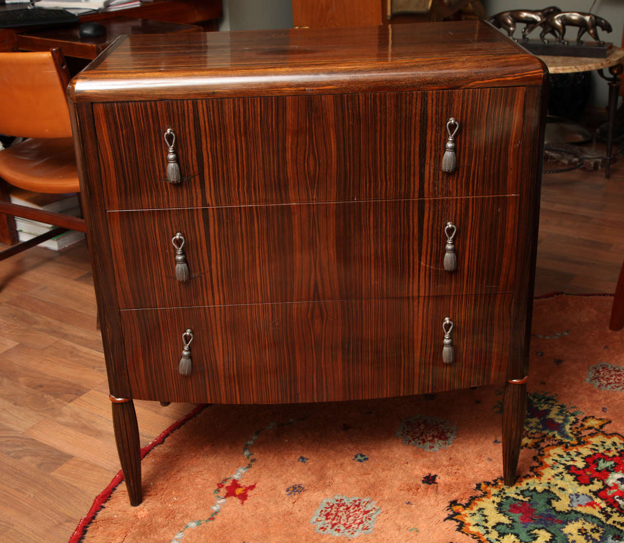 An elegant French Art Deco chest of drawers, veneered in Macassar ebony, with three drawers, silvered bronze trimmings on tapered gadrooned legs, circa 1930.