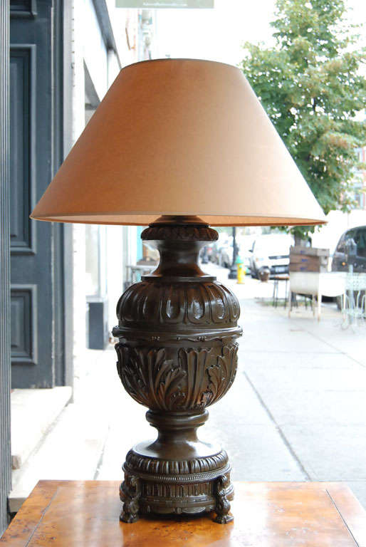 A bold and robust pair of vintage painted and glazed renaissance inspired lamps.  The squat bodies have deep acanthus leaves and a fluted top and are mounted on a metal plinth raised on scrolled legs.  The whole is painted a deep, rich mottled green