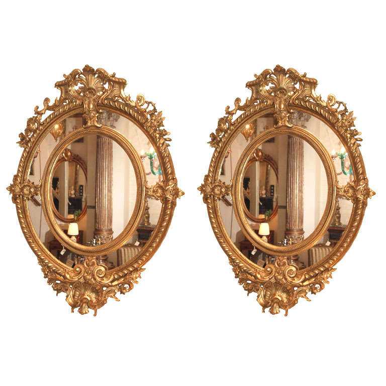 A Fine Pair of Antique Oval Carved Giltwood and Gesso Mirrors For Sale