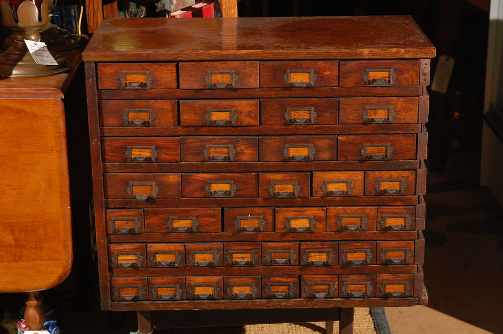 Offering a c. 1900 solid oak store display cabinet with 39 tin lined drawers. Cabinet is hand made, the drawers vary in size, and there are little metal slots on the front of each drawer for a paper or metal label to slide in. Each drawer also has a