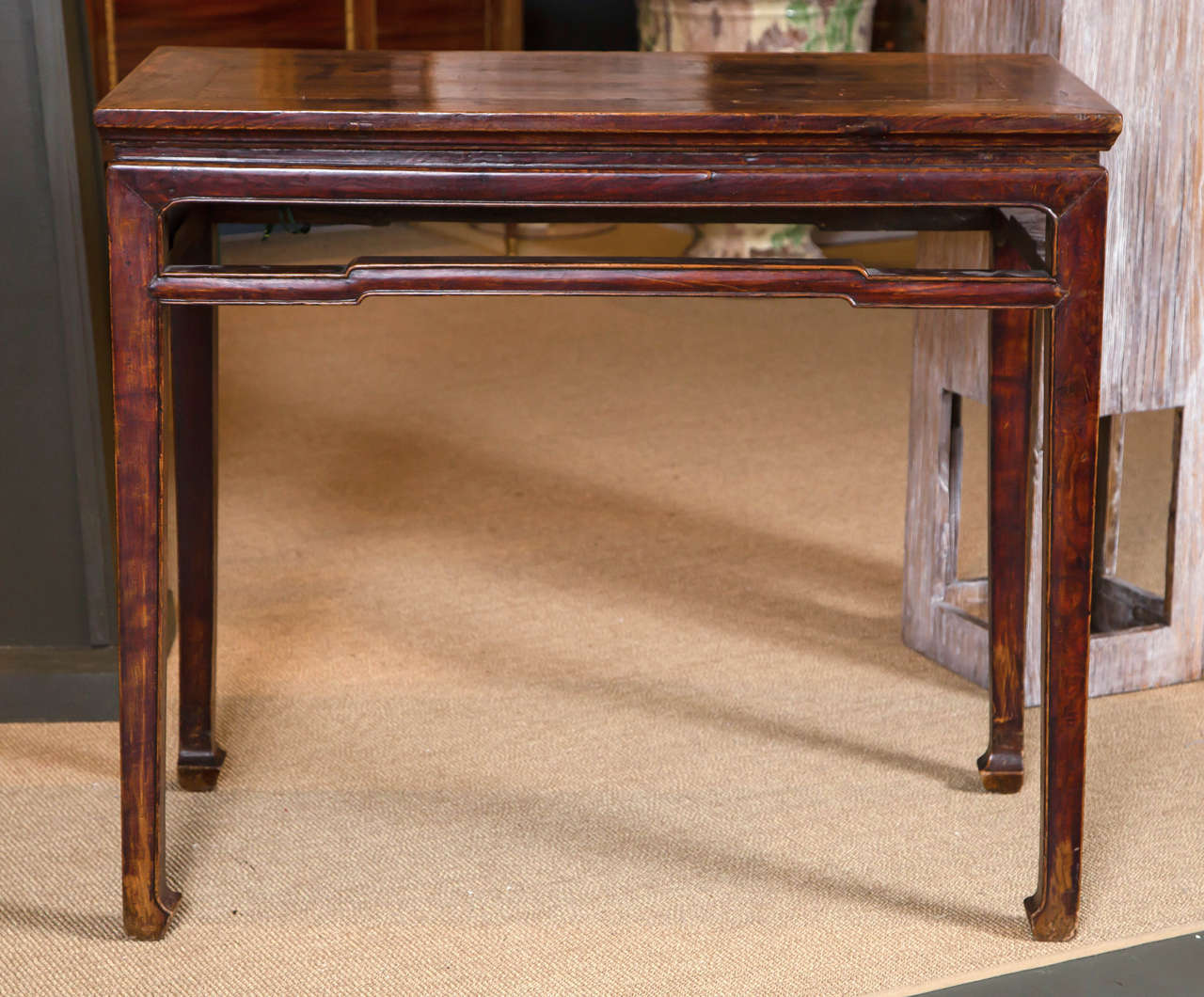 A 19th century Northern Chinese elmwood console table of simple strong lines. The rectangular top over molded frieze and stretchers, square legs ending on horse hoof feet.