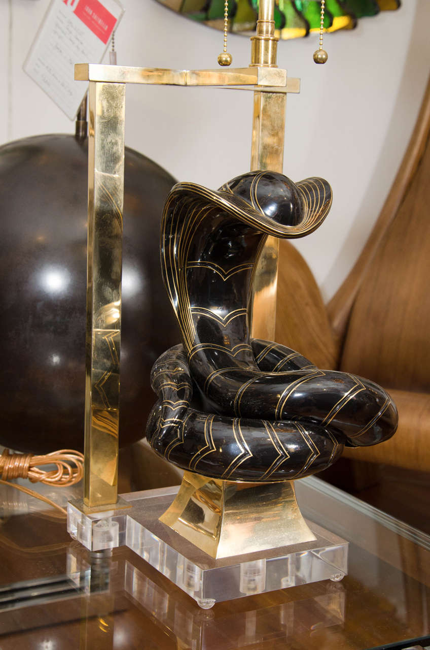 Pair of enameled brass cobra table lamps with brass hardware on Lucite bases in the manner of Tony Duquette.