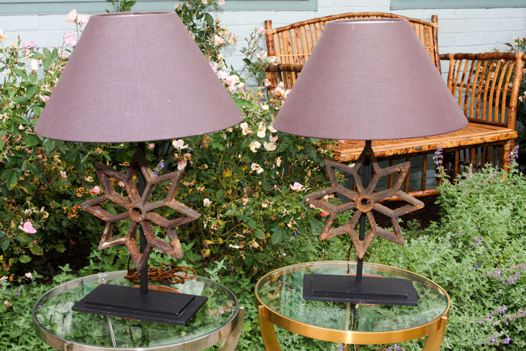 Antique French cast iron stars have been mounted on black metal bases and wired to create these unique table lamps. Priced as a pair, but available individually as well.