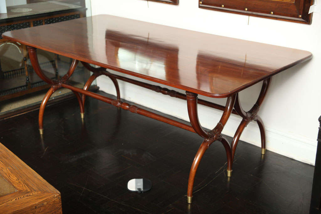 Early 20th century walnut dining table with double curule shape legs with turned cross stretcher.