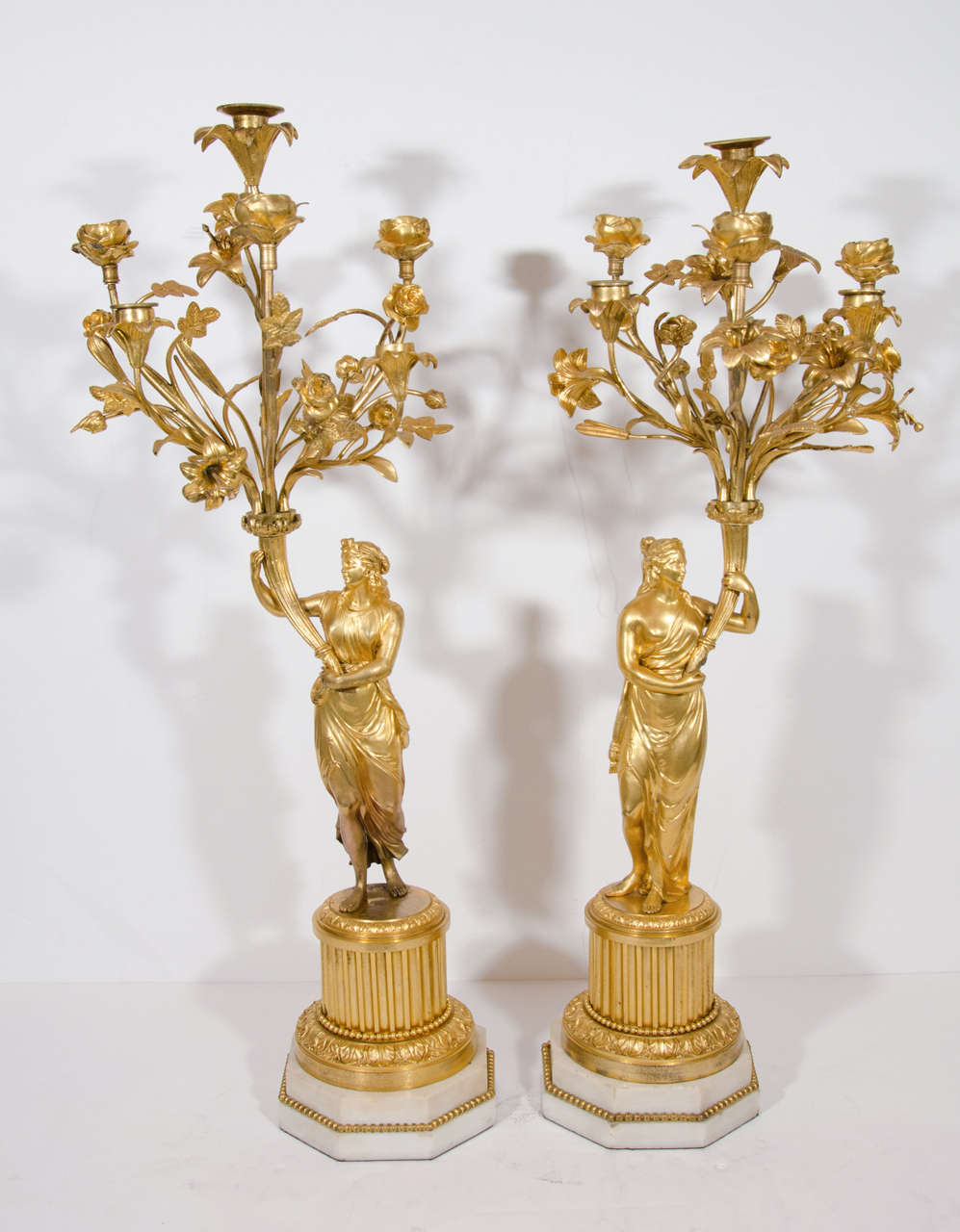 A pair of Large Antique French Louis XVI Style gilt bronze figural multi arm candelabras of exquisite detail. These unique candelabras are embellished with gilt bronze figures of neoclassical ladies and further adorned with branches and flowers
