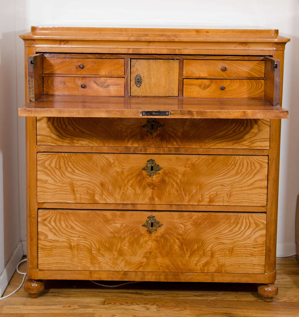 Originally designed as a case piece for a drawing room, the upper drawer folds down to hold the various bits and pieces a butler might have needed to have at hand.  Nowadays, this type of chest normally resides in a bedroom and is a repository of