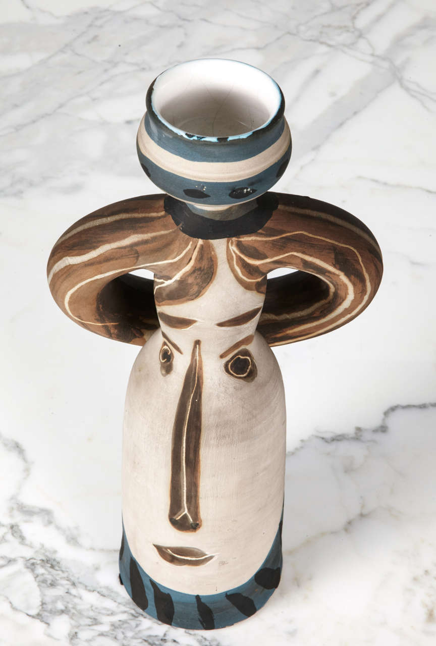 Pablo Picasso (1881 - 1973)
Ceramic vase
Decorated with a face painted in brown on a white background. Handles painted in brown laced with white stripes. Applications of blue on the base and the top.
Stamped 