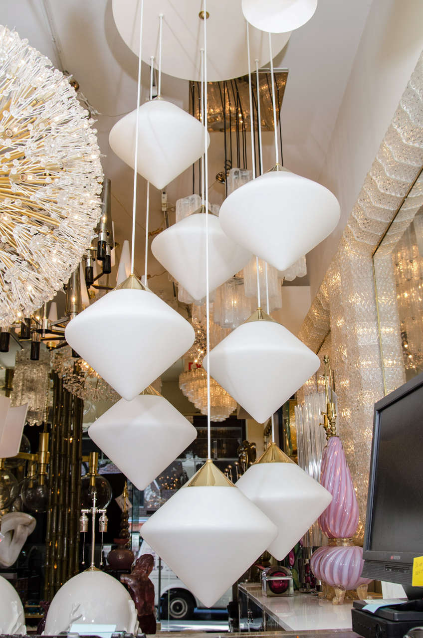 Grand chandelier composed of multiple suspended, geometric frosted glass elements in the manner of Stilnovo.
