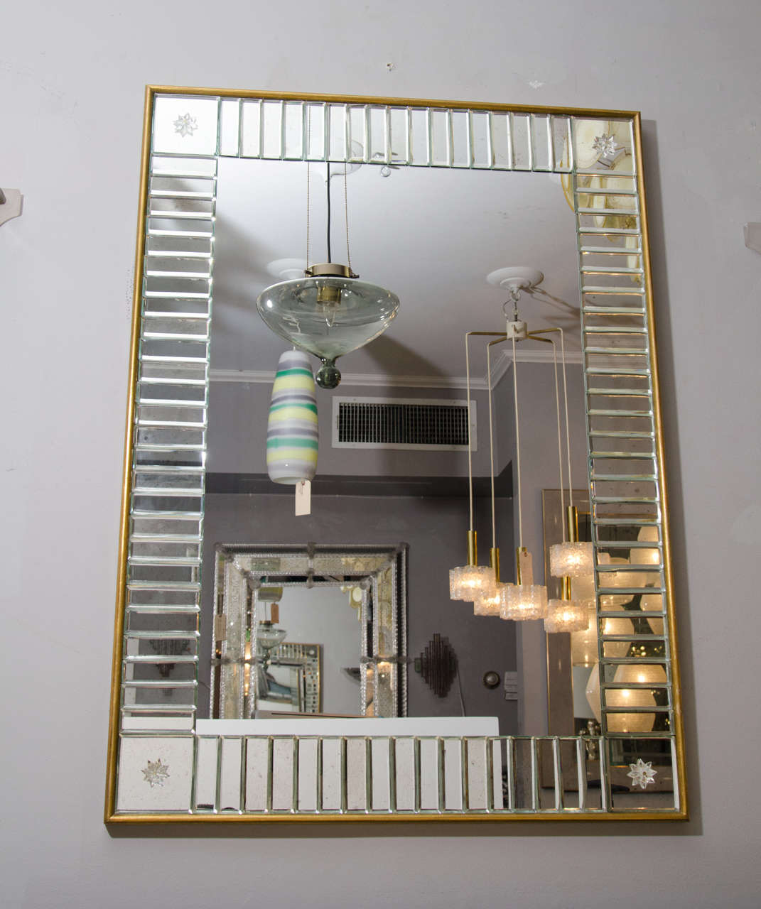 Miroir transparent personnalisé avec baguettes de miroir et cadre en feuille d'or. Des détails de rosaces en verre sont ajoutés aux baguettes des miroirs d'angle. La personnalisation est possible dans différentes tailles.