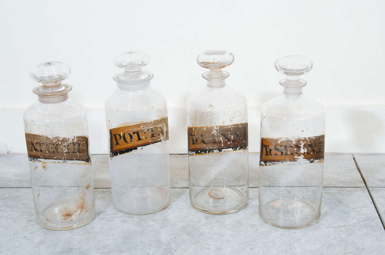 A set of four 19th century pharmacy bottles with painted labels, glass stoppers and pontil bottoms, 
U.S.A., circa 1860.
GL200.