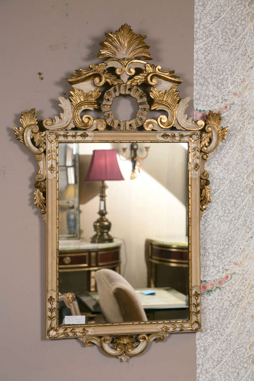 Pair of parcel gilt mirrors. Beautifully carved representing the ideal of the Rococo period which symbolizes delicacy and romantic style along with feminine and light details. Italian Rococo style is represented in its fullest with the features of