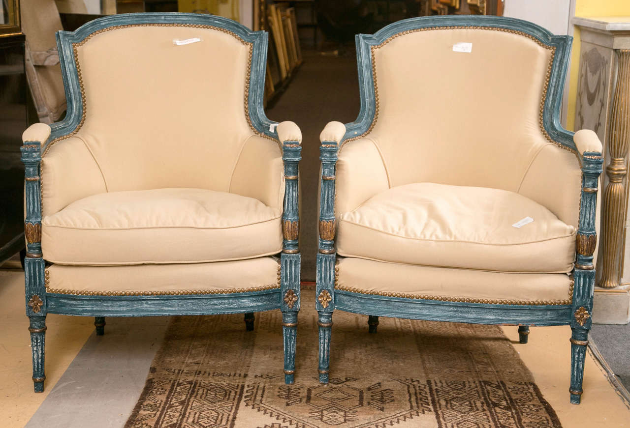 Pair of Louis XVI style chairs by Maison Jansen. These fine quality Louis XVI style chairs have been paint decorated in a fine celeste blue with gilt gold highlights. The set of four legs supporting a pair of down cushioned seats with wooden and