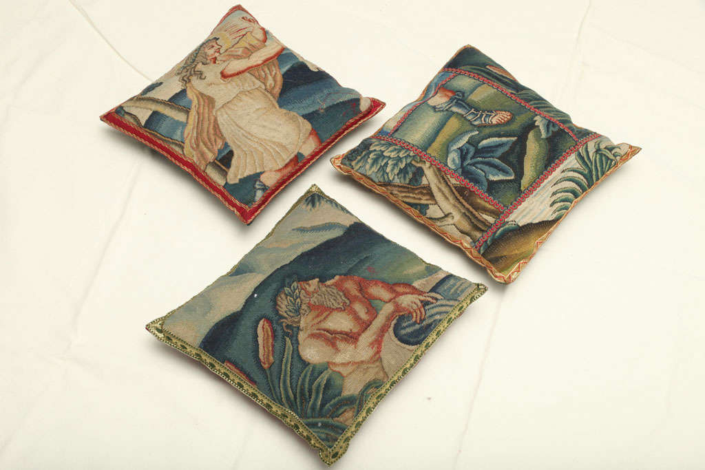 EACH SQUARE WITH MODERN FABRIC BACKING, THE FRONT PANELS DEPICTING MYTHOLOGICAL FIGURES ON TWO CUSHIONS AND A LEG WITH A ROMAN MILITARY BOOT (CALIGAE) ON.