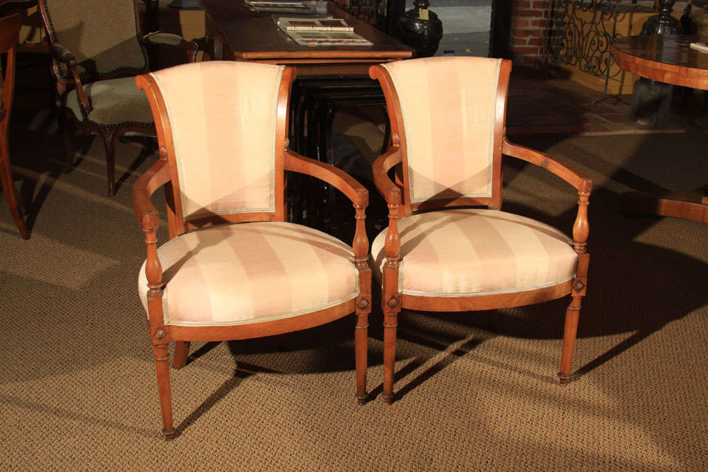 Pair of Directoire Style Fauteuil Chairs in Cherry Wood

Lovely pair of medium sized open arm chairs with upholstery. The back features a scrolling fan back and the arms have the classic Directoire shape which continues down the front legs to the