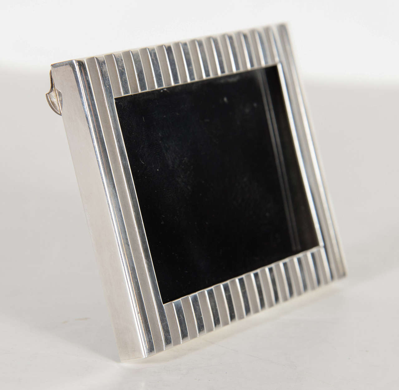 This Art Deco style sterling silver frame features a ribbed design in polished and matte sterling's. It is fitted for a 3 by 2 picture and bears the mark Tiffany Sterling.