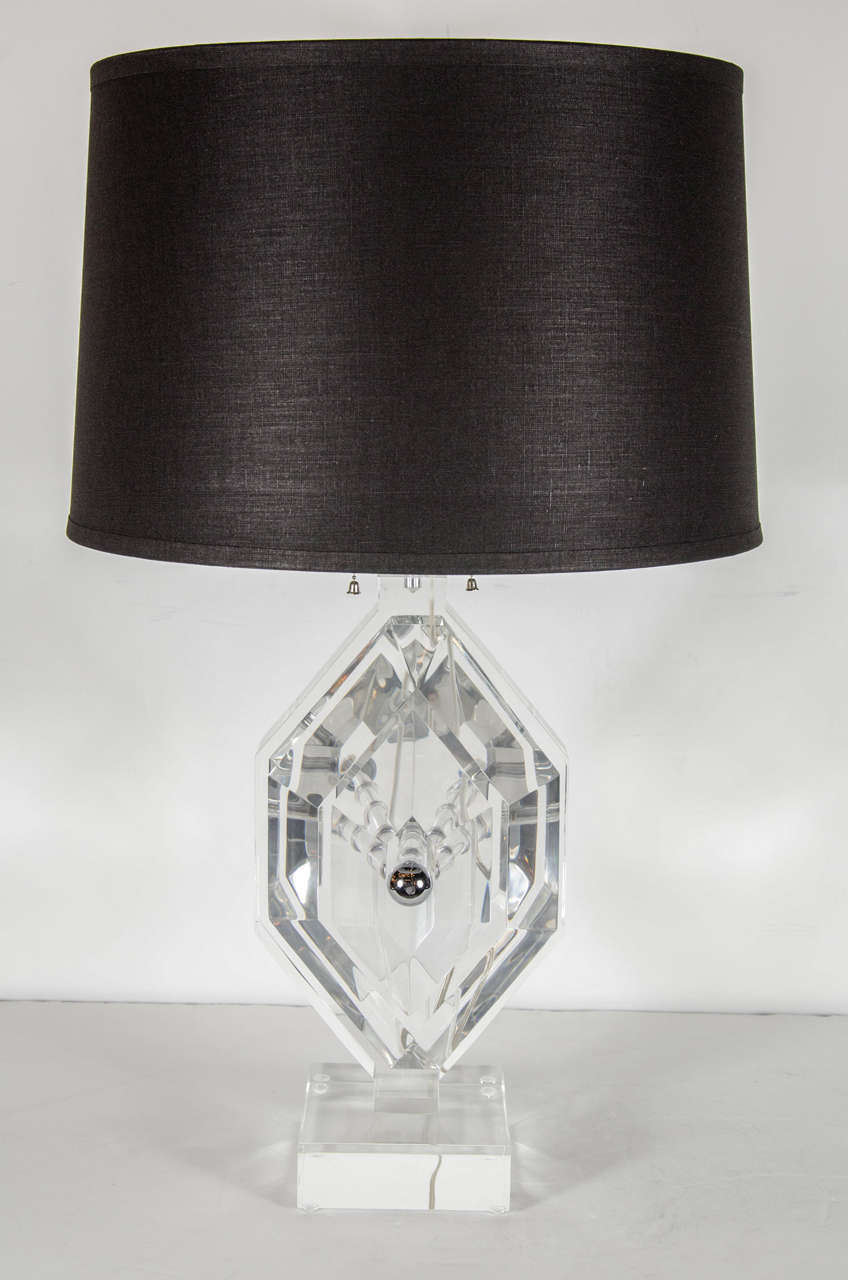 Mid-Century Modernist lucite table lamp with chrome fittings by Les Prismatiques. This stunning table lamp consists of thick lucite diamond shaped panels that are stacked together in a descending fashion from the lamps center support by a thick