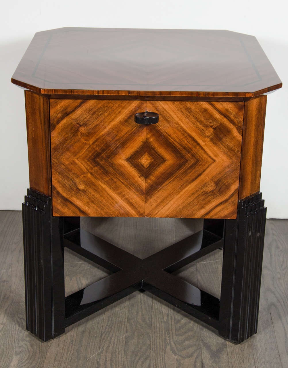 This impressive Art Deco bar table features four drop-down doors which open to reveal the interior space inside. The book-matched walnut is inlaid to create symmetrically geometric designs on all surfaces for both the interior and exterior. The