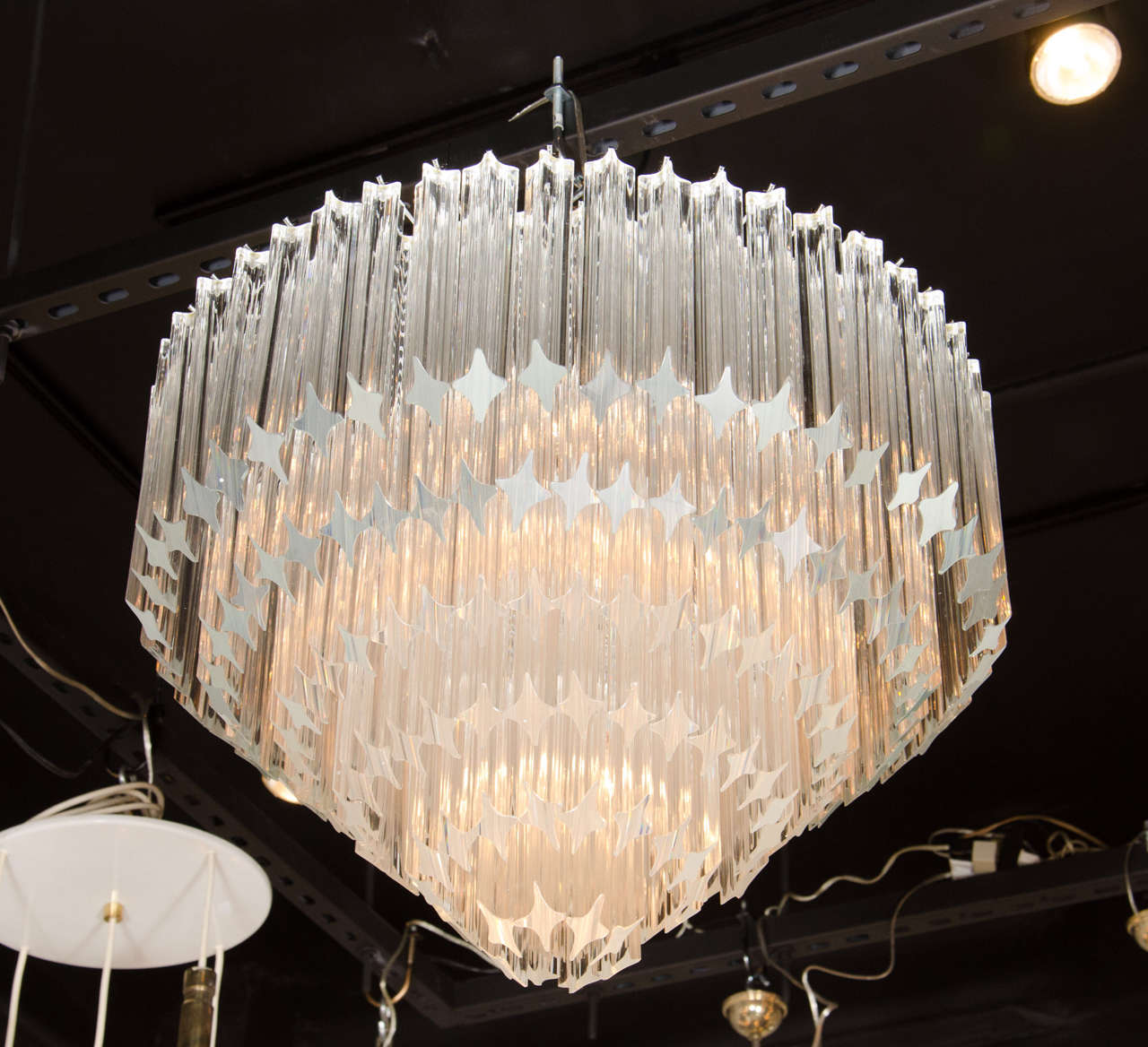 This exceptional Mid-Century Modernist Camer chandelier by Venini features individually handmade Murano glass triedre prisms hung in six tiers that have been cut at an angle and individually hung from its chrome frame. Each of the six tiers of
