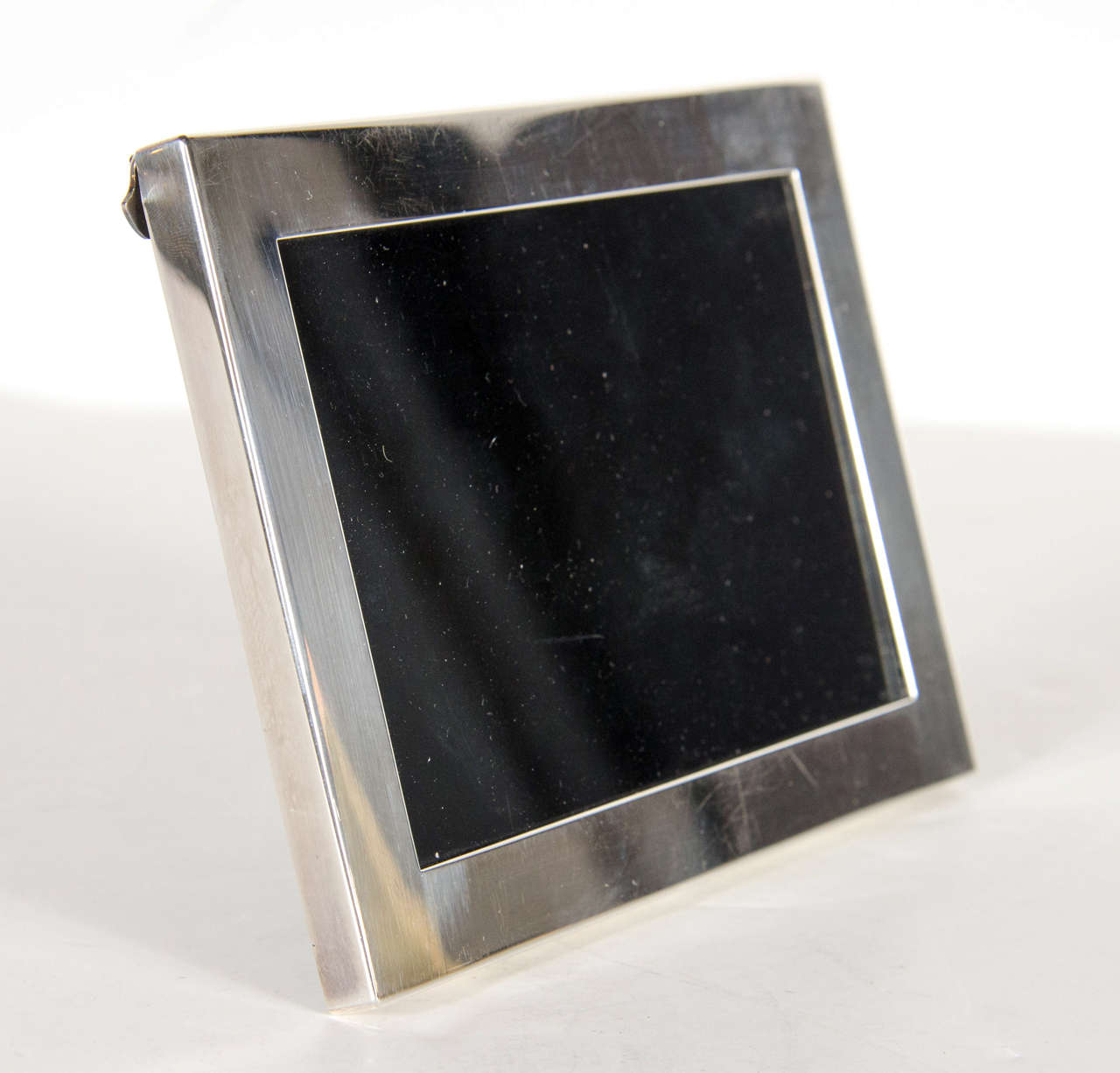 This sophisticated Mid-Century Modern sterling silver picture frame by Tiffany & Co. holds a 5