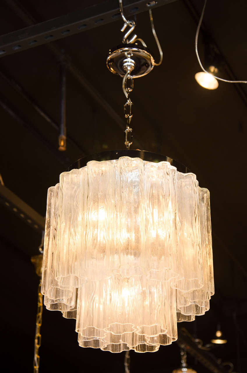 Mid-Century Modern Tronchi chandelier by Venini features a circular two-tier design consisting of multiple Murano glass clear textured tubes suspended from chrome fittings. This chandelier can be used as a pendant or flush mount, it has five