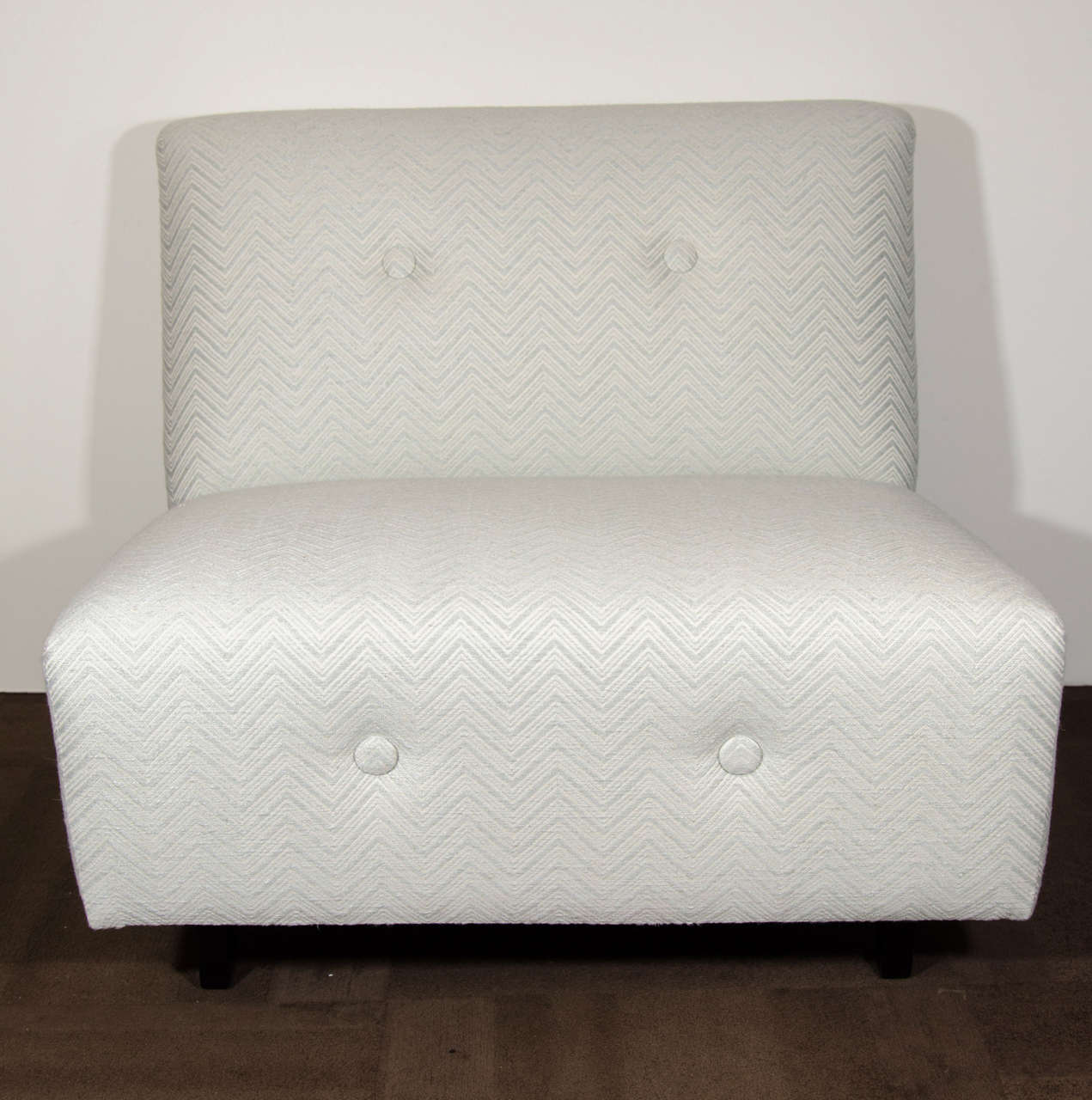 Elegant pair of Art Deco lounge chairs upholstered in woven Scalamandre fabric with a gorgeous chevron pattern in hues of ivory and matte silver. The chairs have large classic square back and seat design Features large button accents along the back