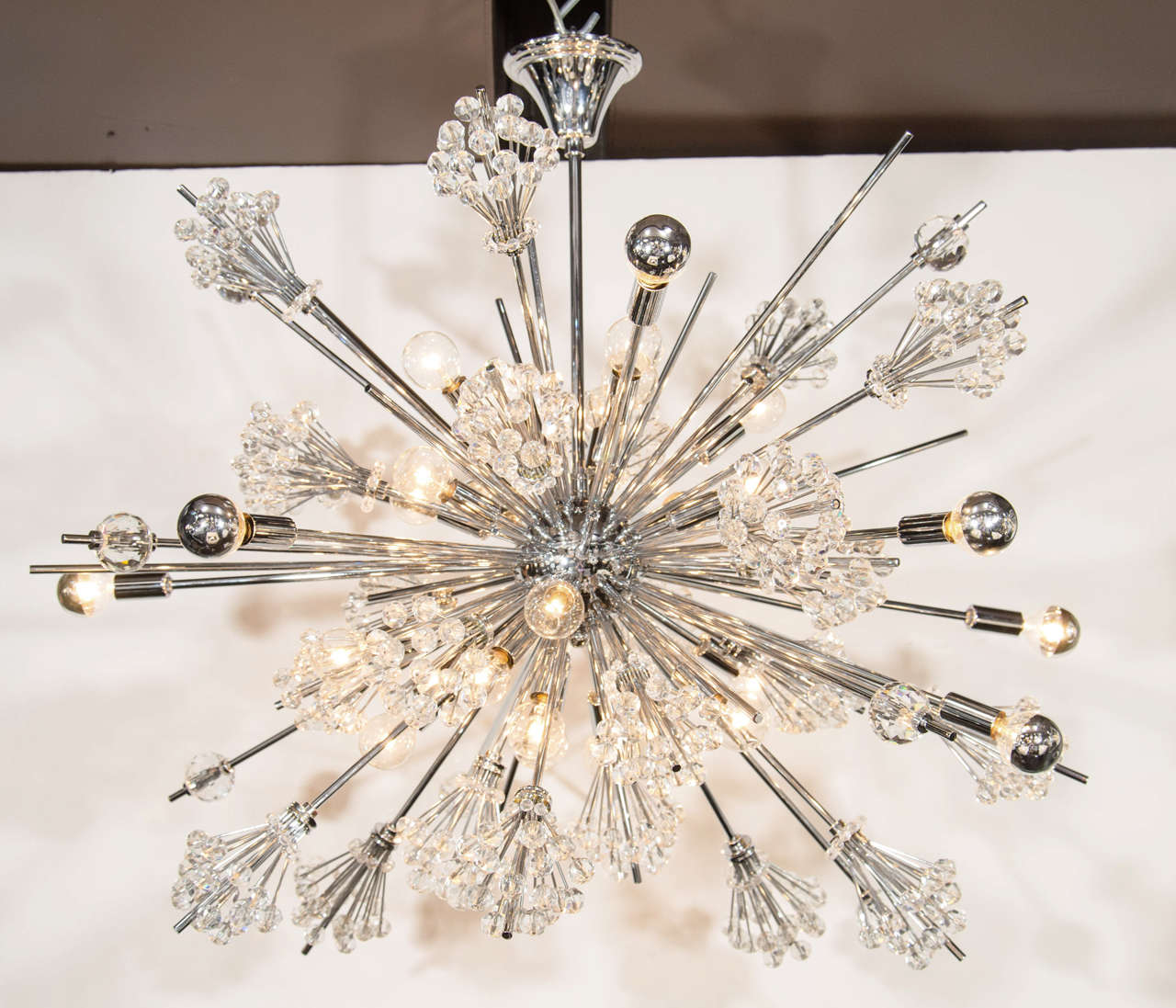 Rare and outstanding chandelier with starburst design, comprised of polished nickel atomic sputnik frame and fittings, and with clusters of Austrian hand cut crystals throughout. Fitted with an amazing 28 lights. This piece is a smaller variation of