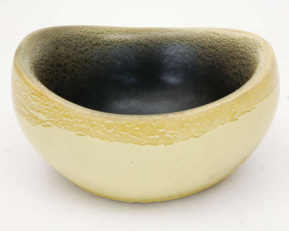 An excellent and rare example of Russel Wright's ceramic work for the California Pottery Bauer, this bowl has an acid yellow exterior that darkens to a black interior. Signed on the bottom (see Images 6 & 7).