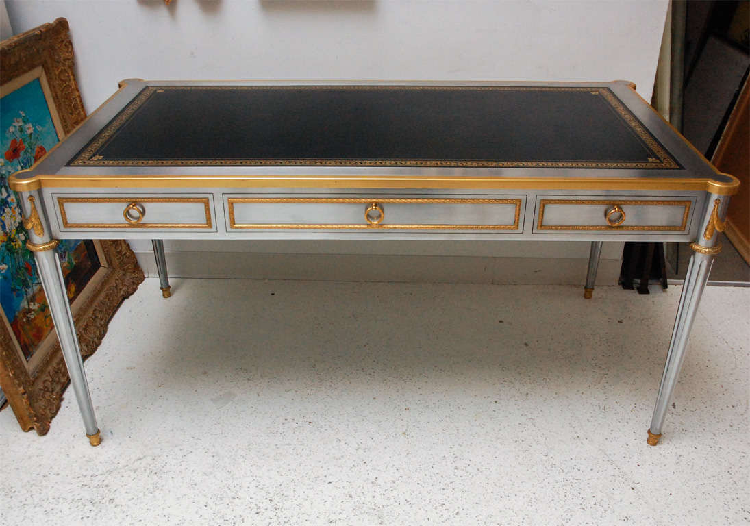 An absolutely fantastic steel desk by John Vesey with bronze dore mounts, hardware by P.E. Guerin and original gold embossed leather top. The desk has three drawers, including one with a combination lock as well as two pull-out shelves on either