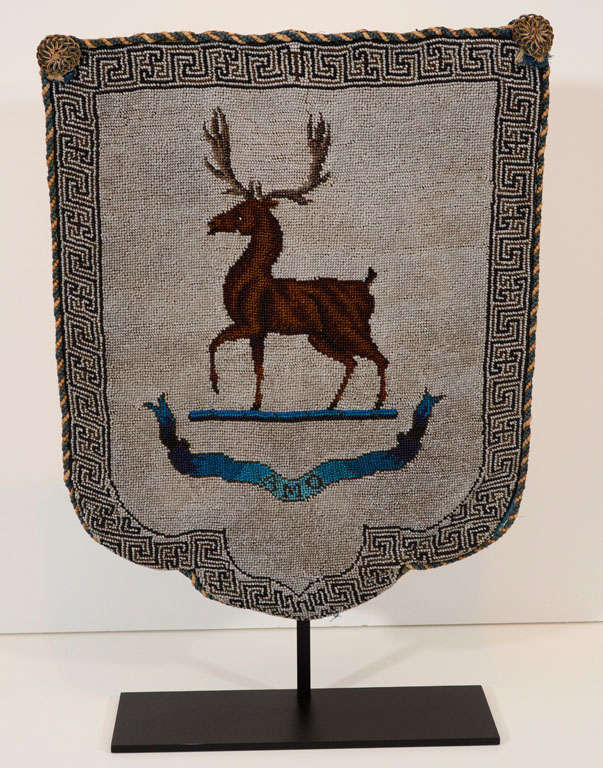 An unusual late 18th century English cut glass and cut steel beadwork panel depicting a stag above a ribbon plume with the word AMO within a Greek key border

mounted on a contemporary stand
