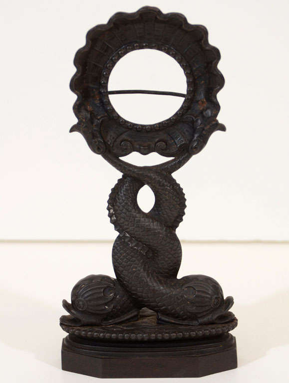 An early 19th century German Berlin ironwork pocket watch stand with entwined dolphin base