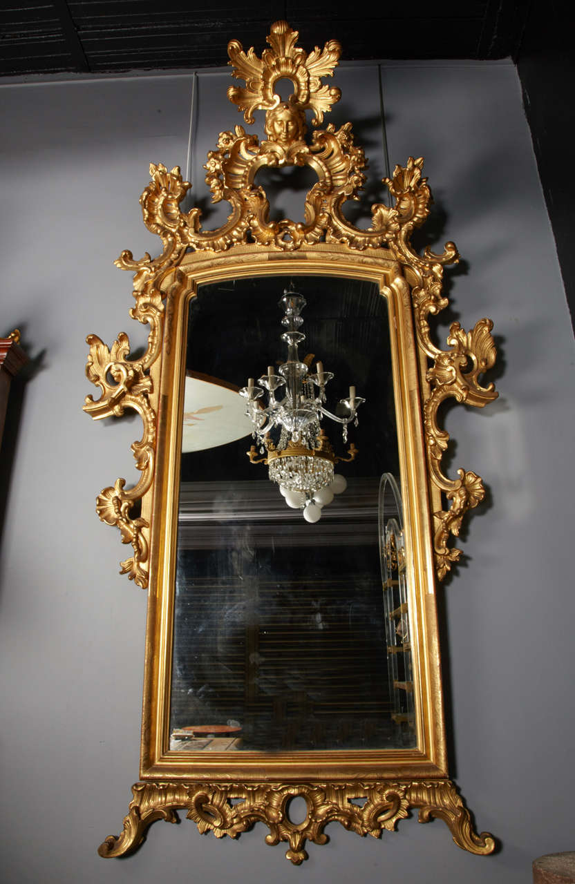 19th Pair of Venetian mirrors in gilded wood, finely carved and 
spellings. With antique glass in mercury