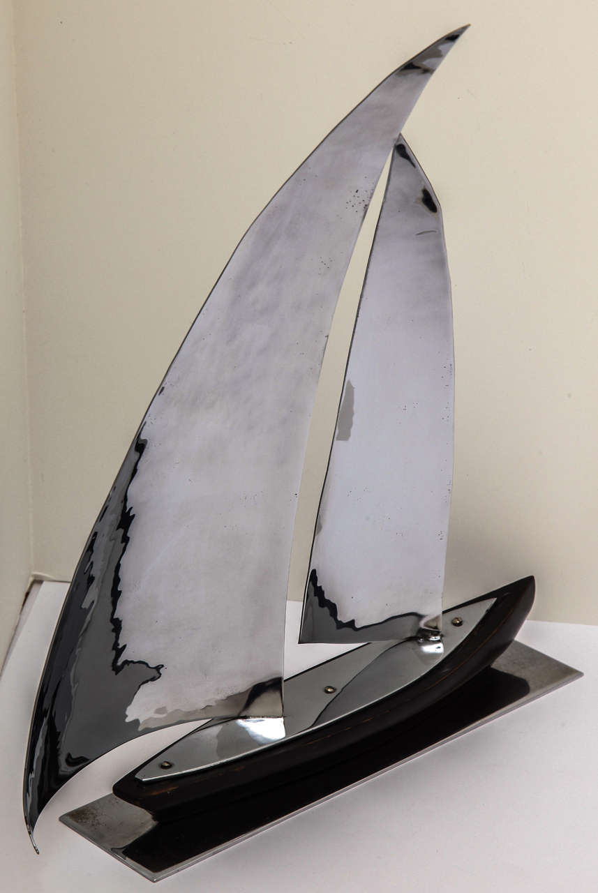 An Art Deco sailboat sculpture by Hagenauer. Chrome plated metal is beautifully hammered to create the large billowy sails. The boat is hand-carved  of ebonized wood. The underside is signed Hagenauer, Made in Austria, and wHw for Weiner Werkstatte.
