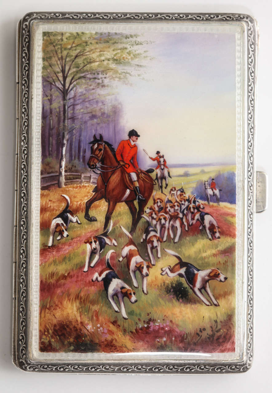 A beautifully hand painted enameled cigarette case in sterling silver. The vibrant scene is highly detailed and very well executed. The sterling case has all over engine turned pattern with a scroll work framing the border on each side. There is a
