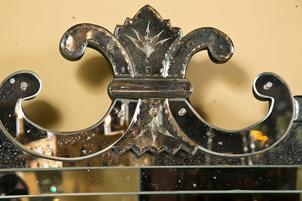 A decorative and unique Venetian style over-the-mantle mirror, the glass in the middle is clear, the bordering is distressed.