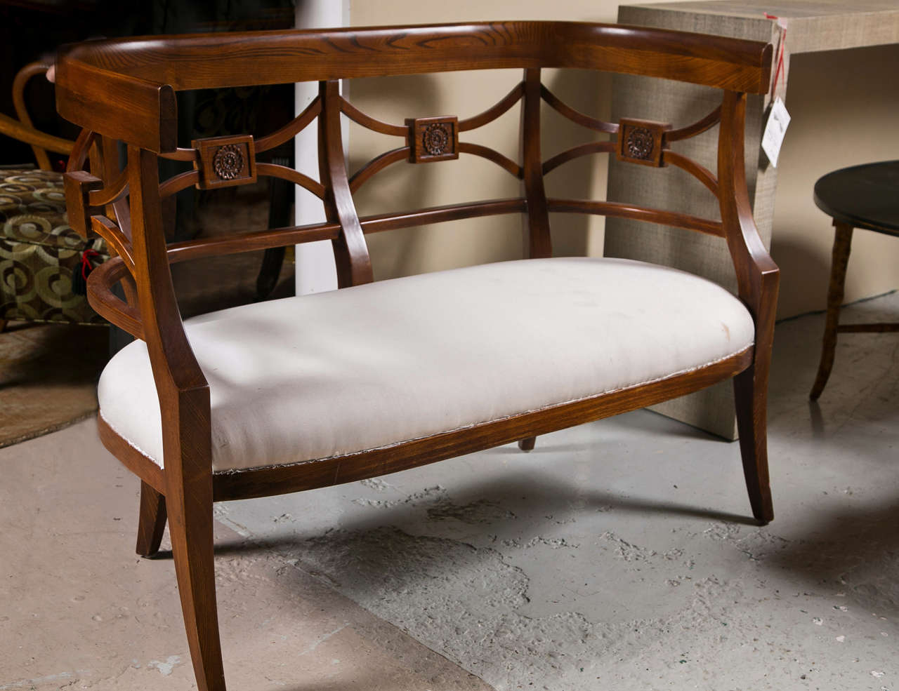 Pair of rosewood settees or loveseats in the Sheraton taste, circa 1970s, the concave-shaped back with patera-decorated back splats joint with a padded seat, raised on splayed legs.